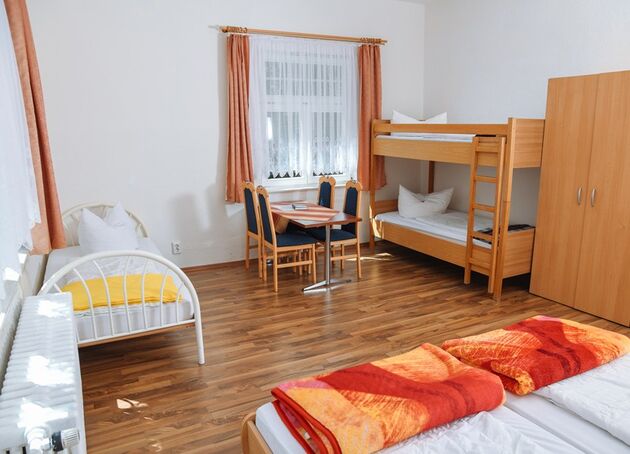 Familienzimmer mit Etagenbett, Kinderbett, Doppelbett und Esstisch