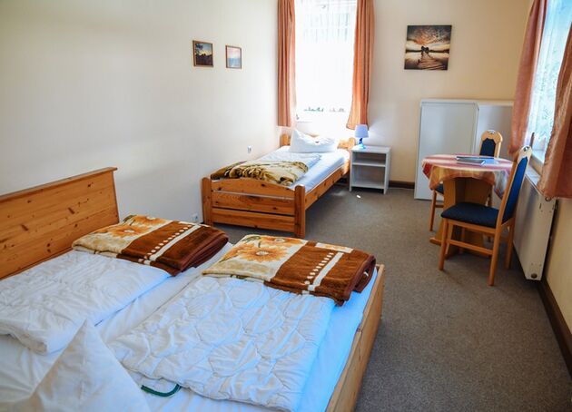 Dreibettzimmer mit Doppelbett, Einzelbett und Sitzecke am Fenster